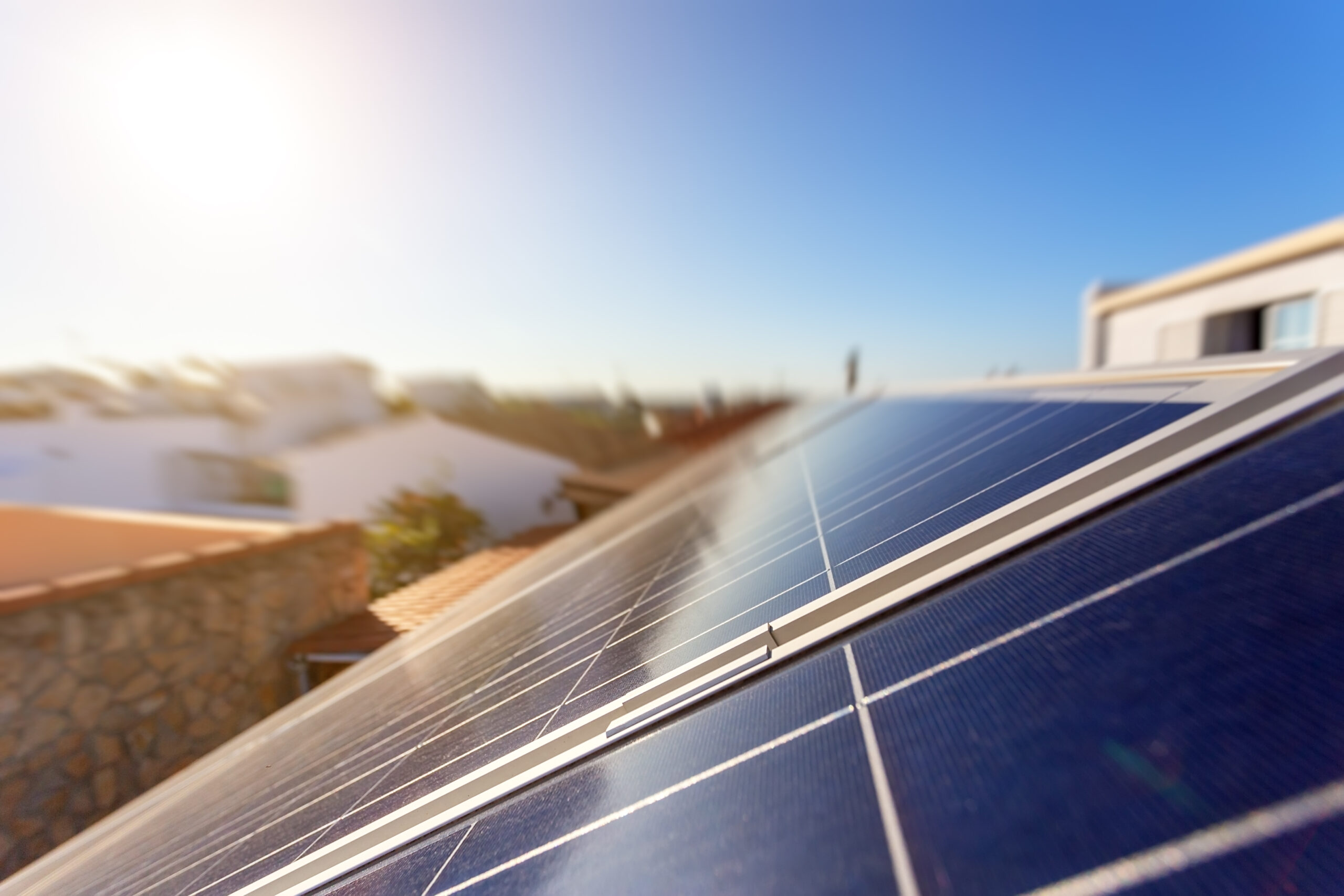 painéis solares com casas ao fundo